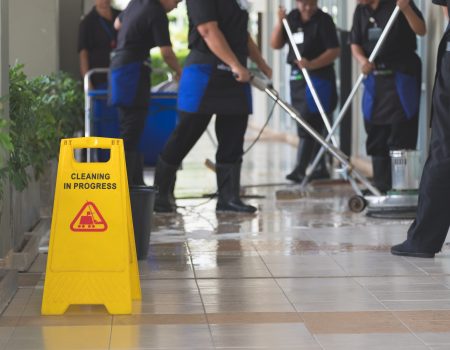 Cropped image of group of woman in protective gloves using a flat wet-mop and machine while cleaning floor