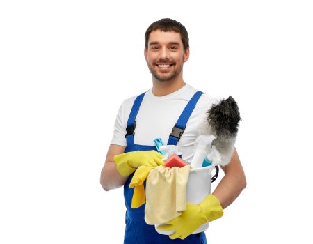 profession, service and people concept - happy smiling male worker or cleaner in overall and gloves with cleaning supplies over white background